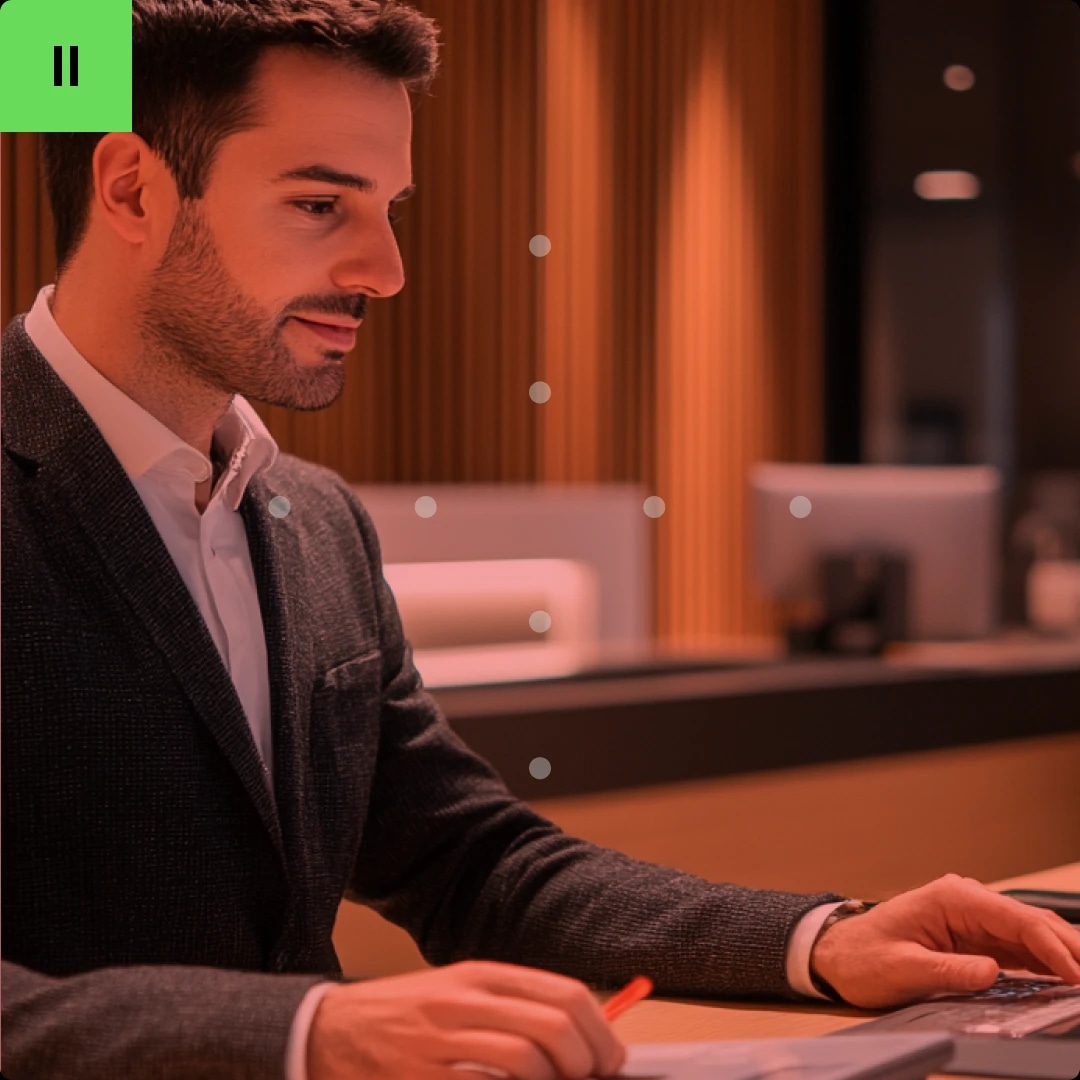 A man in a suit working at a desk in an office setting.
